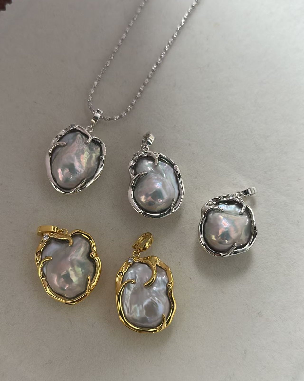 Set of pearl jewelry pieces with gold and silver accents on a white background