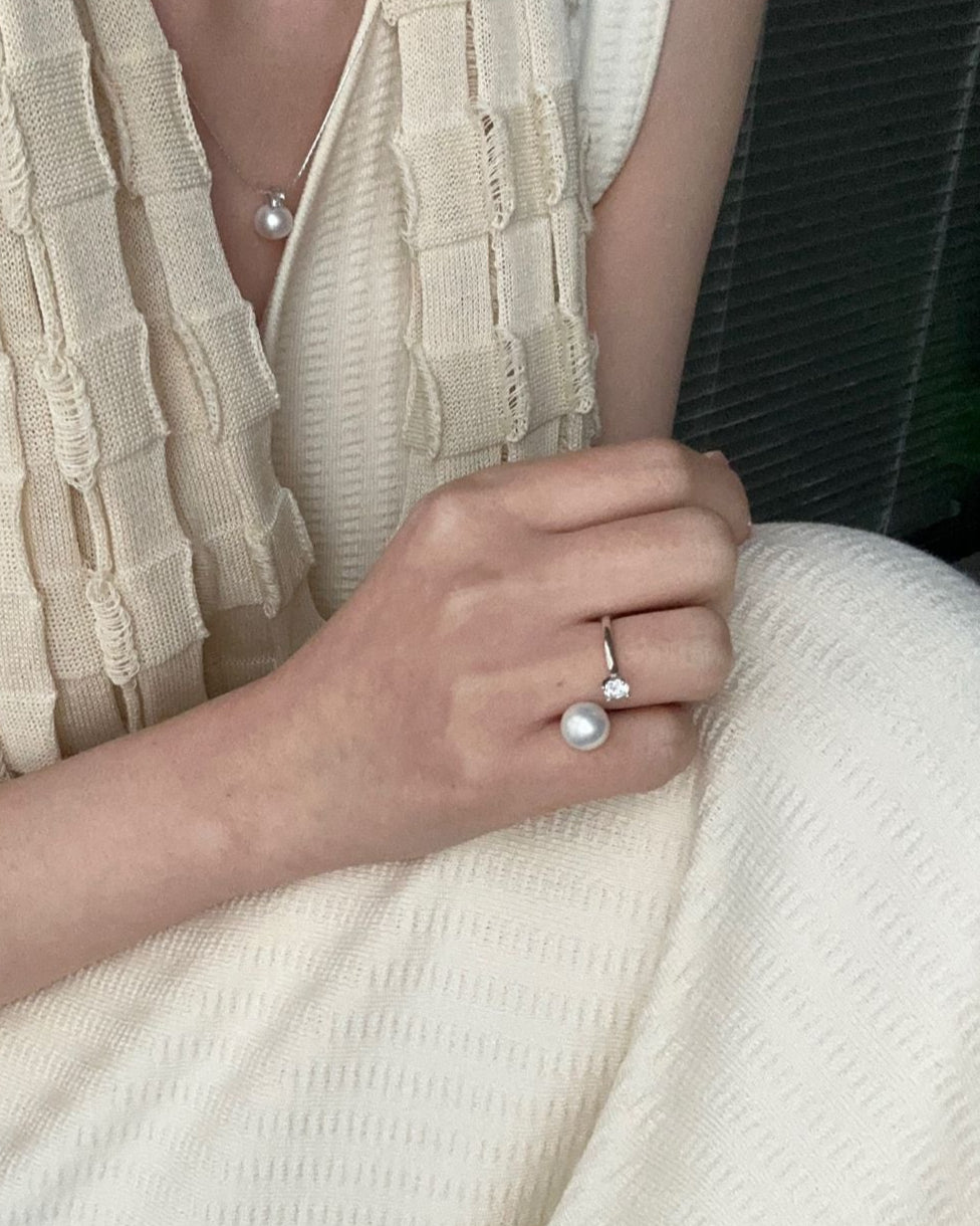 Person wearing a beige sleeveless top and holding a white blanket.