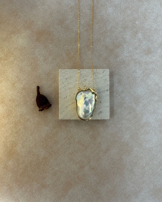 Necklace with a pendant on a beige stone surface