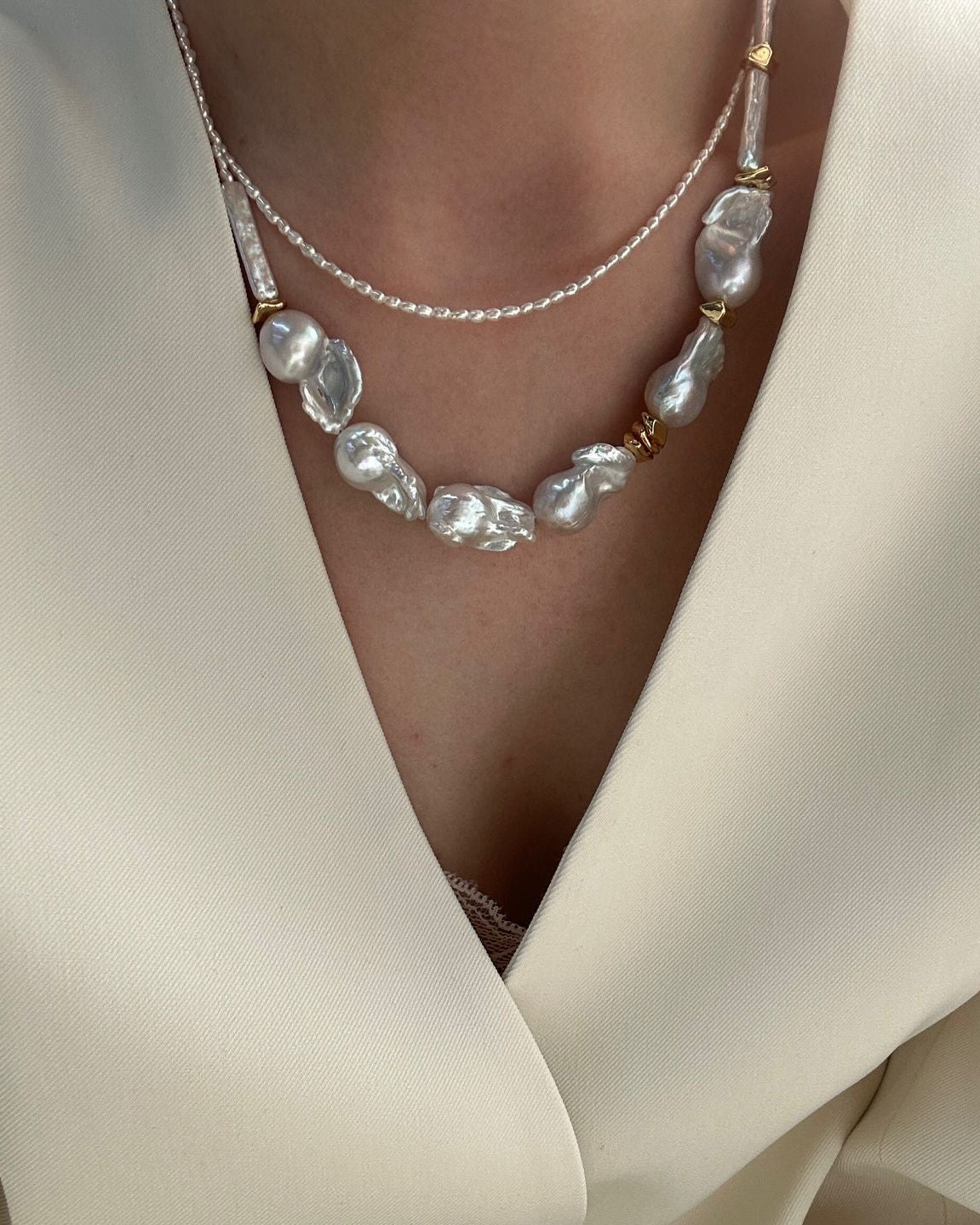 Pearl necklace worn with a white garment