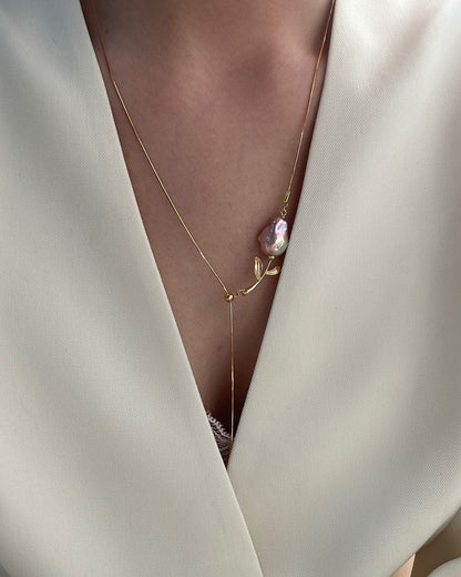 Necklace with a pink pendant on a white garment