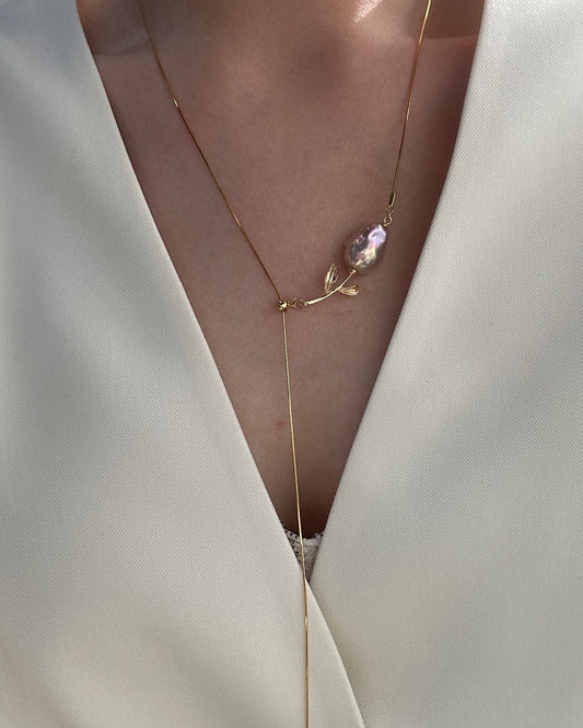 Necklace with a pink pendant on a white garment