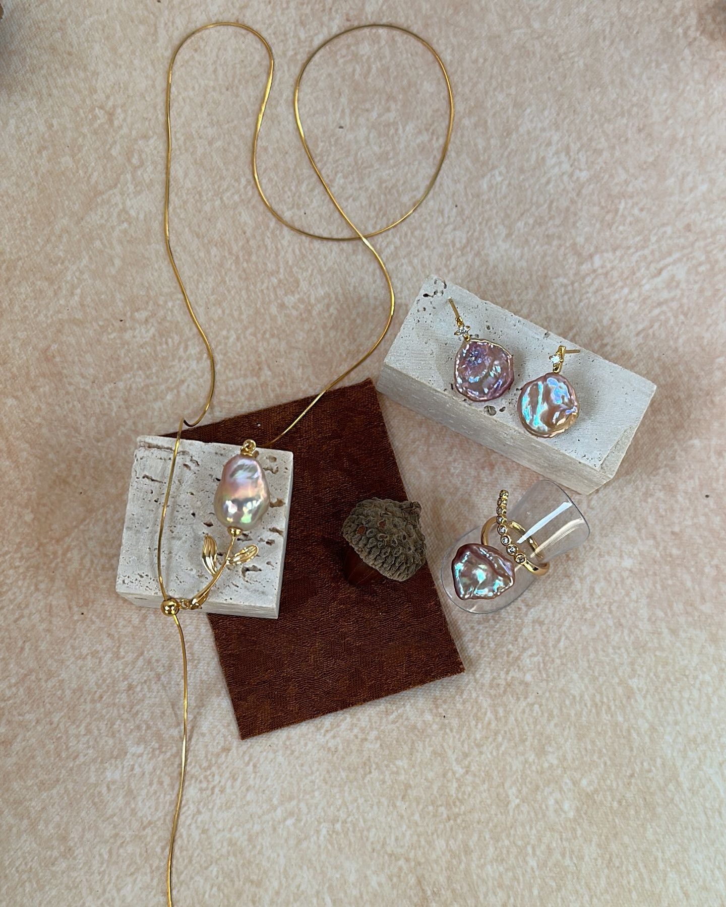 Jewelry set with necklaces and earrings on a beige surface
