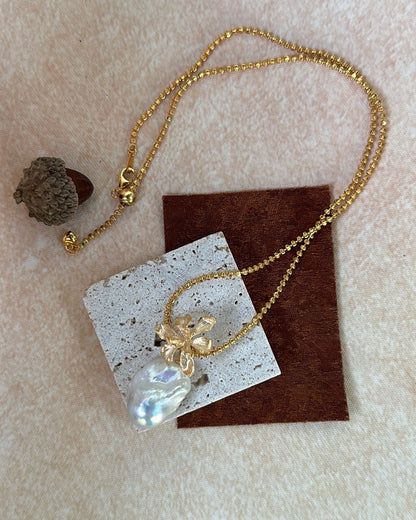 Gold necklace with a pendant on a textured surface