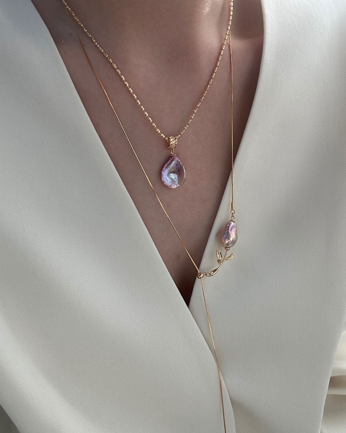 Necklace with a pink pendant on a white outfit