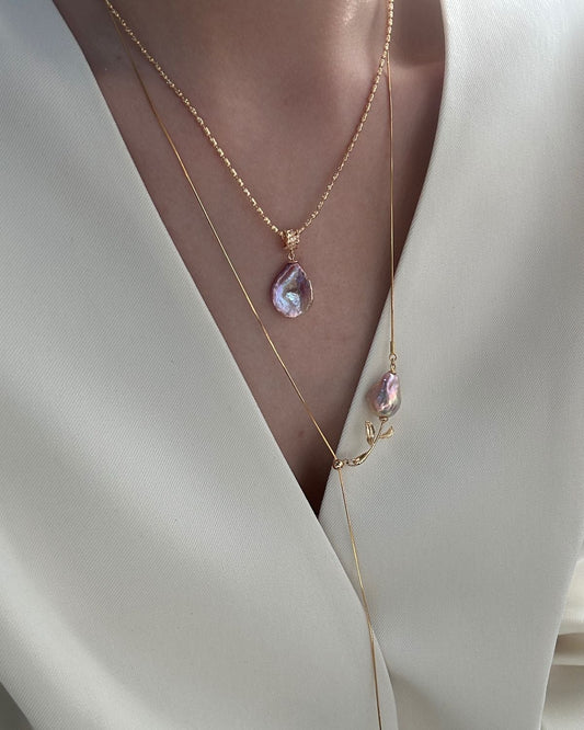 Necklace with a pink pendant on a white outfit