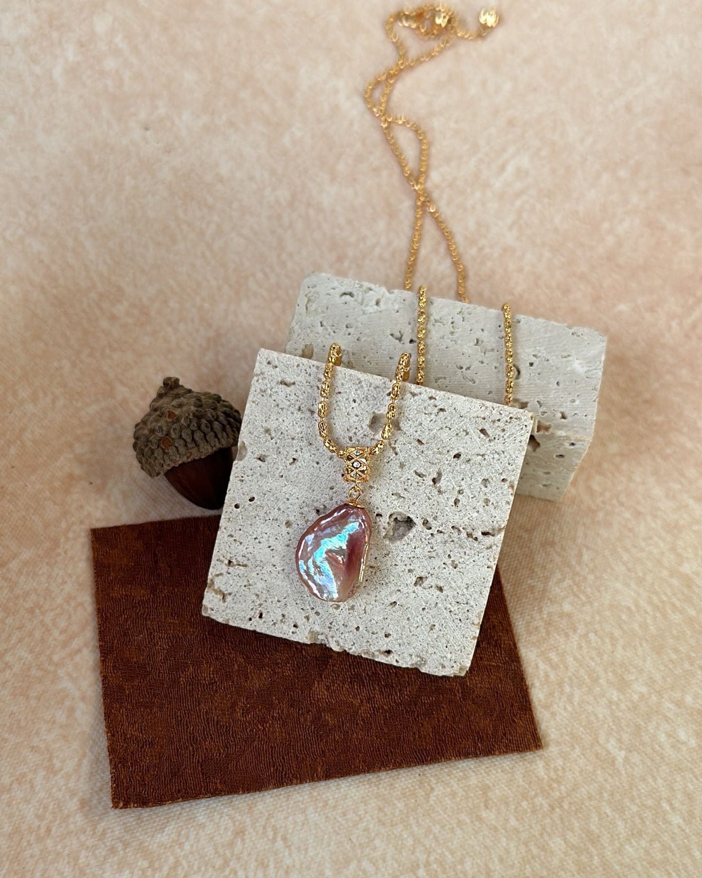 Necklace with a pendant on a textured card against a beige background