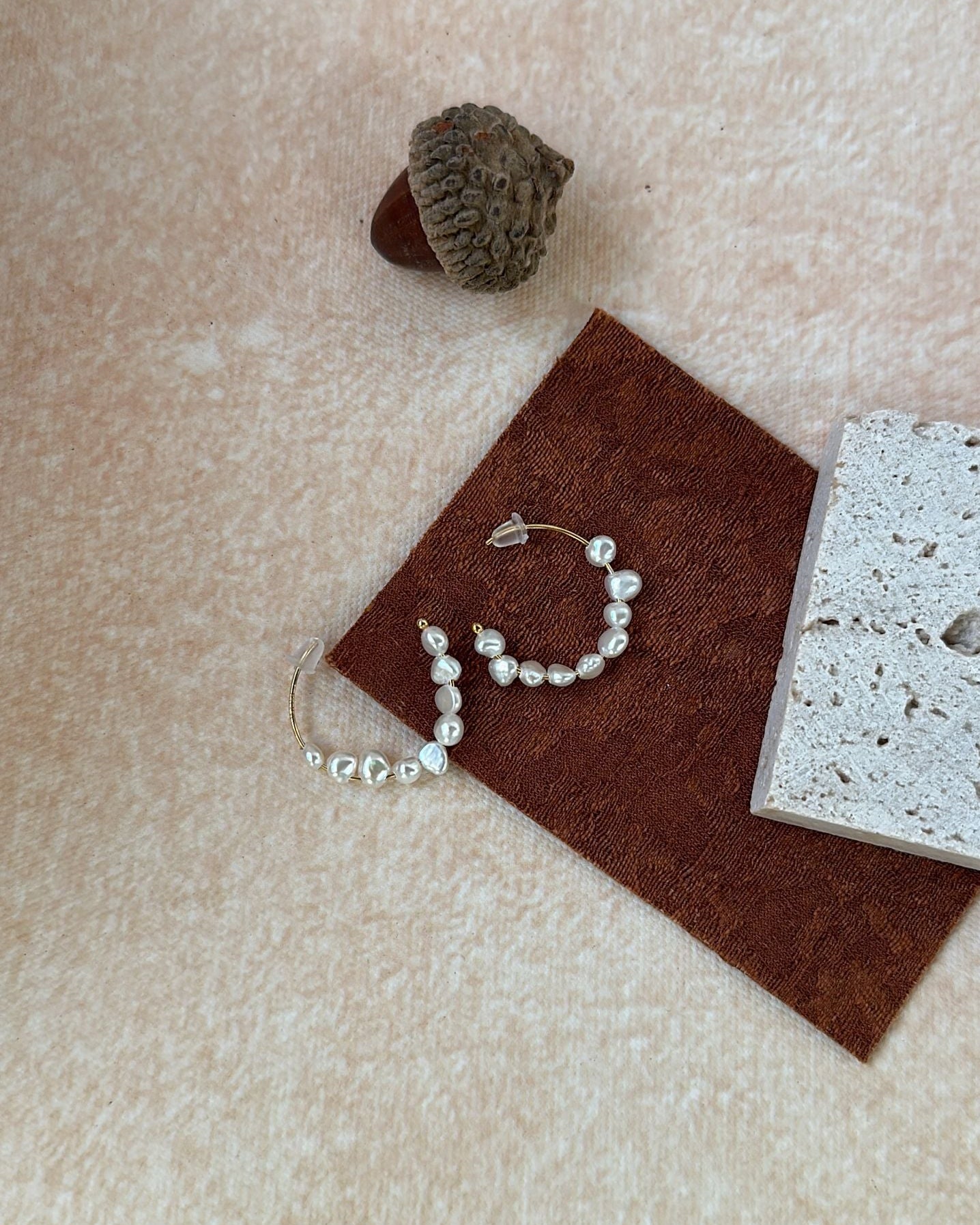 Pearl bracelet on a brown fabric pad with a textured surface background