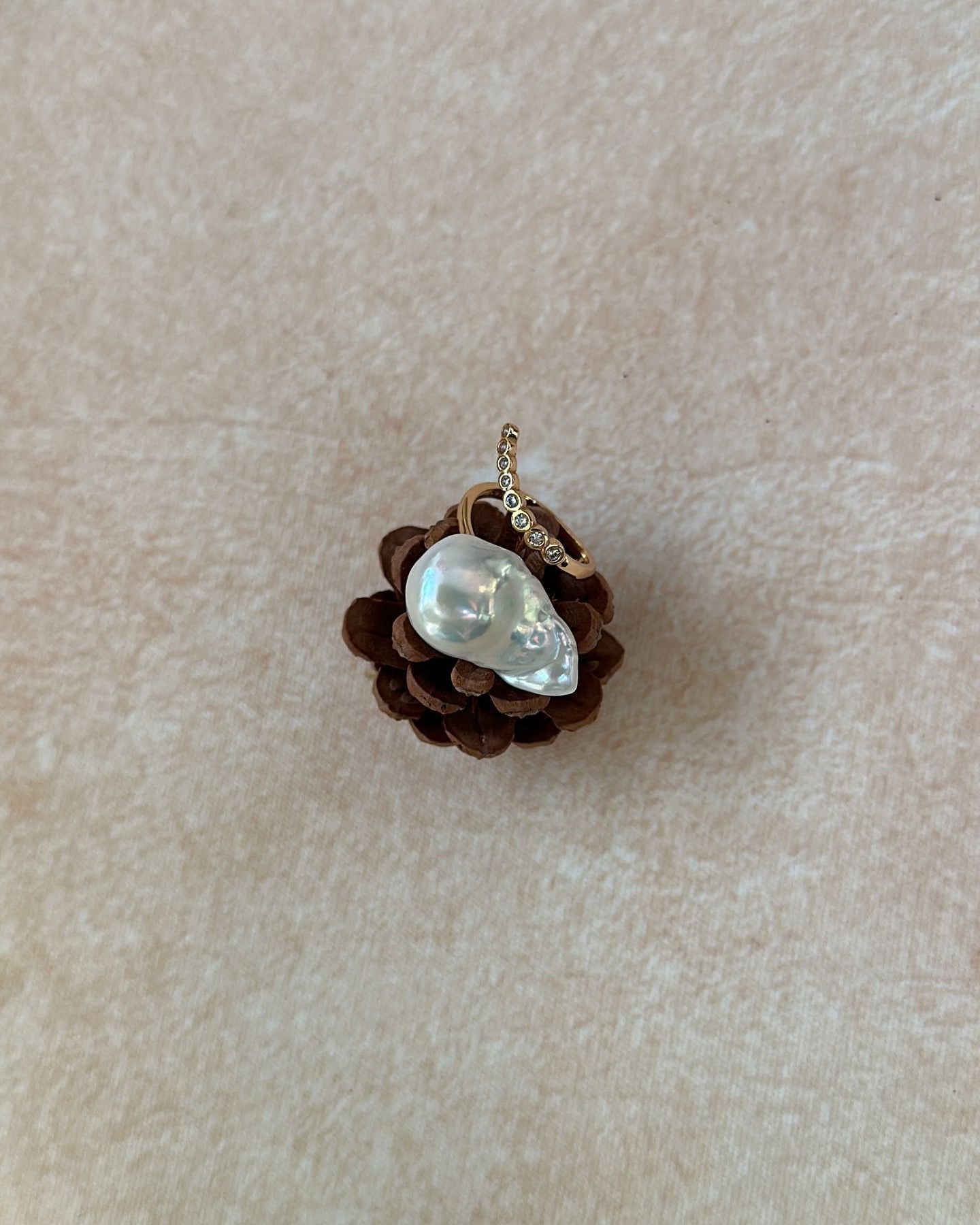 Small pendant with a central gemstone on a beige fabric background