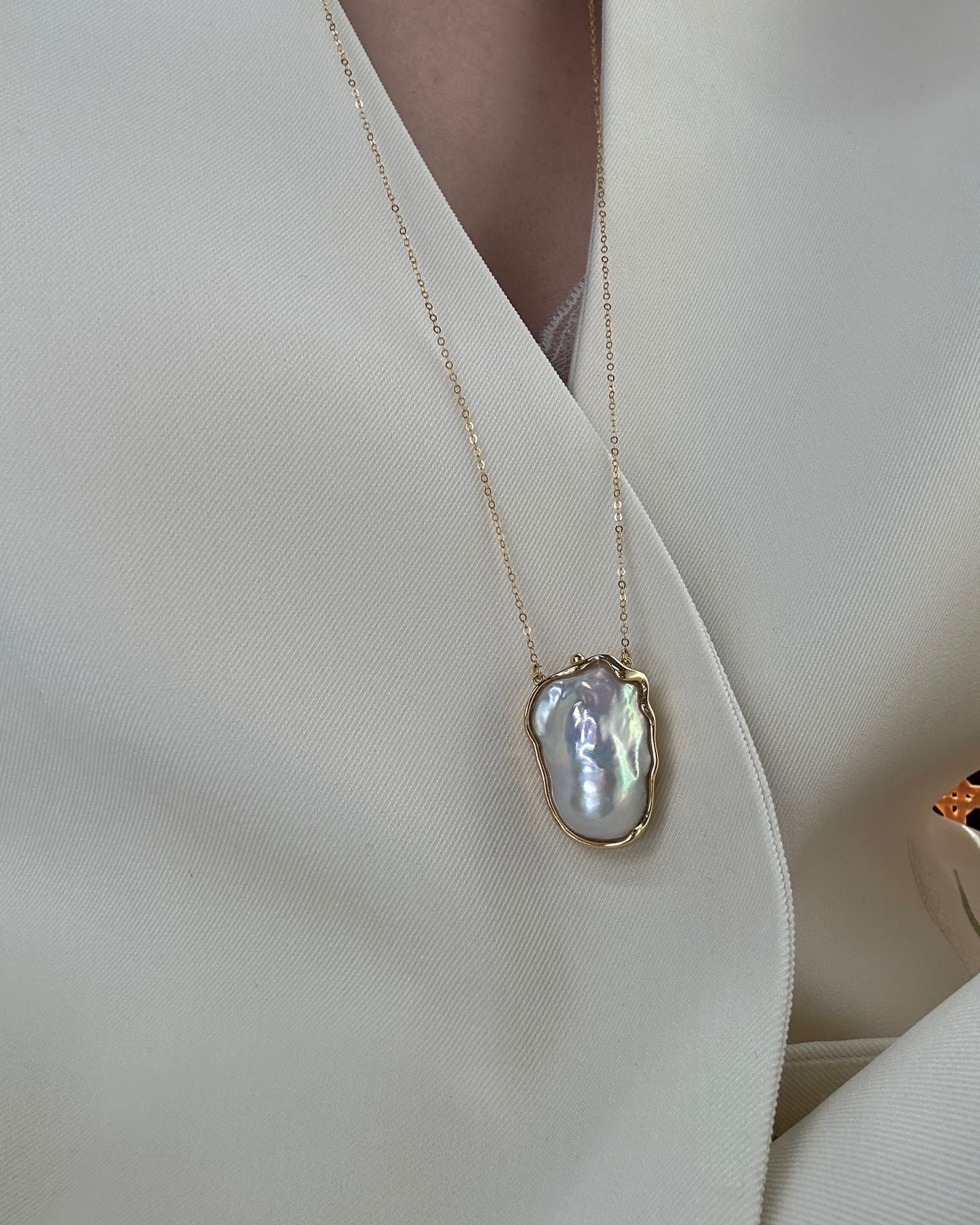 Pearl necklace on a person wearing a white outfit