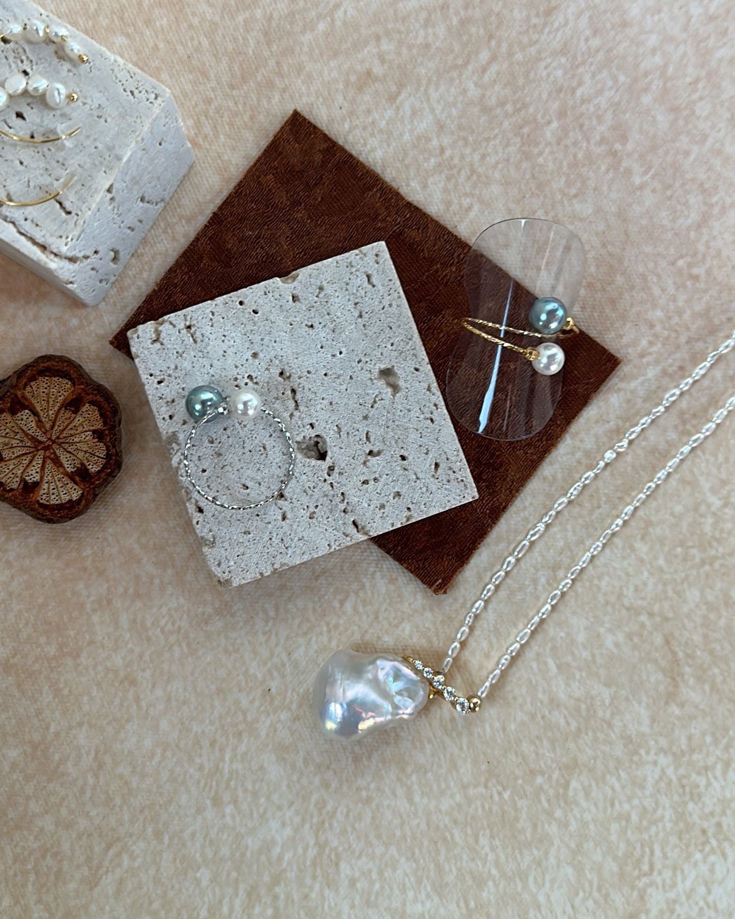 Silver jewelry including a necklace and earrings on a textured surface