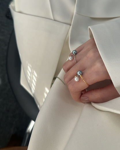 Close-up of a person wearing multiple rings on a beige suit background