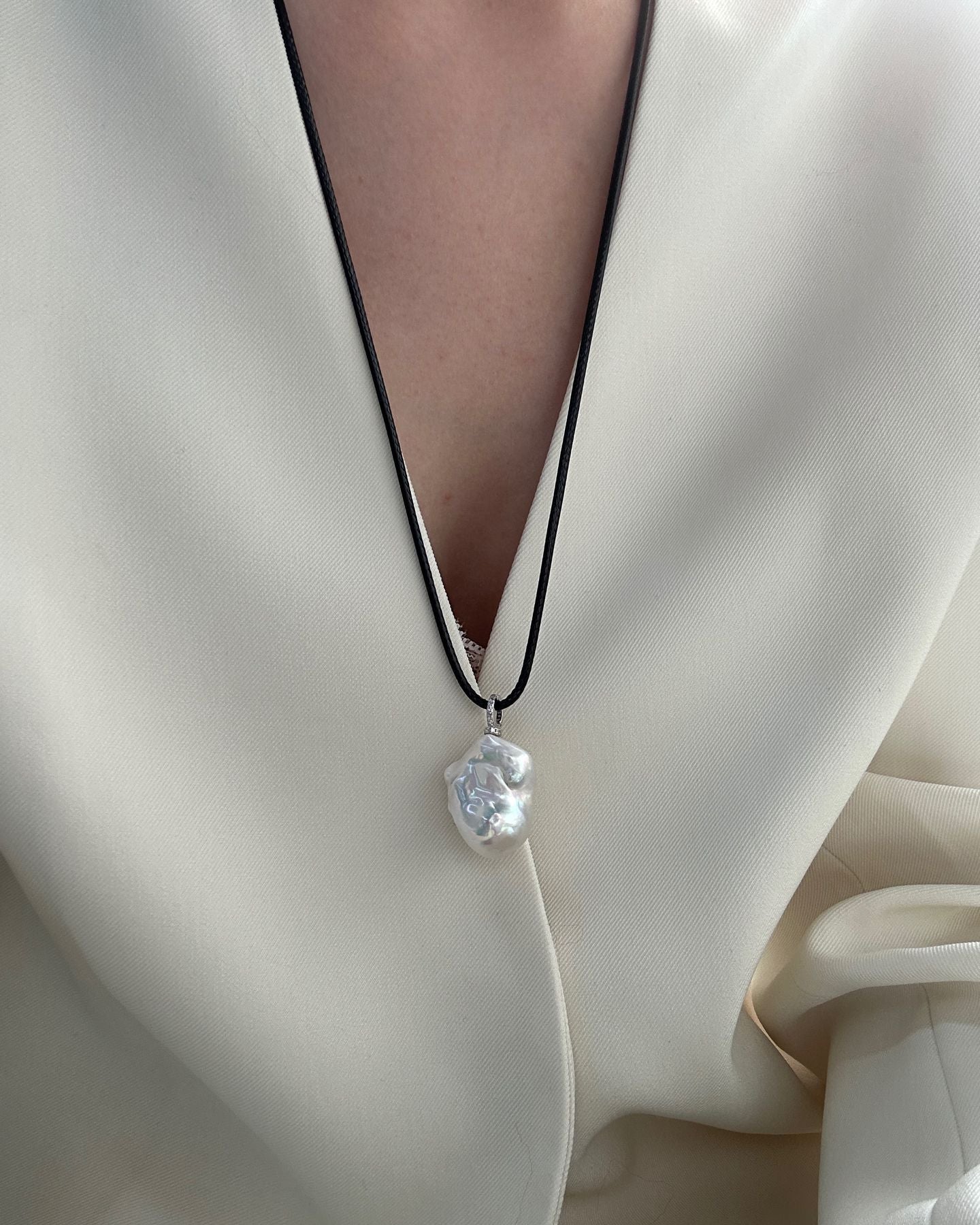 Pearl necklace on a person wearing a white outfit