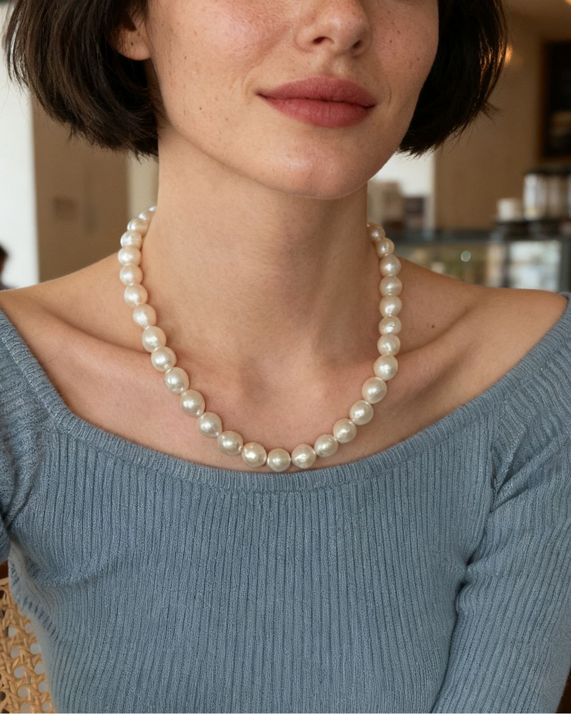 Woman wearing a pearl necklace in a cafe setting